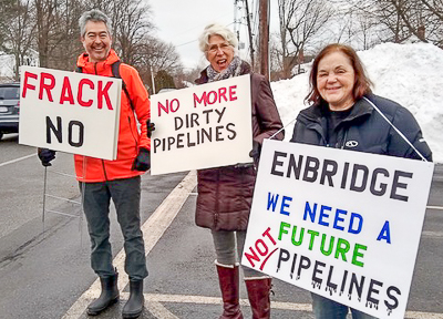 Protesters hold signs by the road