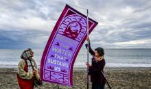 Judith Black and Reverend Kendra Ford raise banner "Protect the water that sustains us."