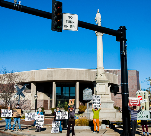 Advocates hold signs for passing drivers at Peabody Square