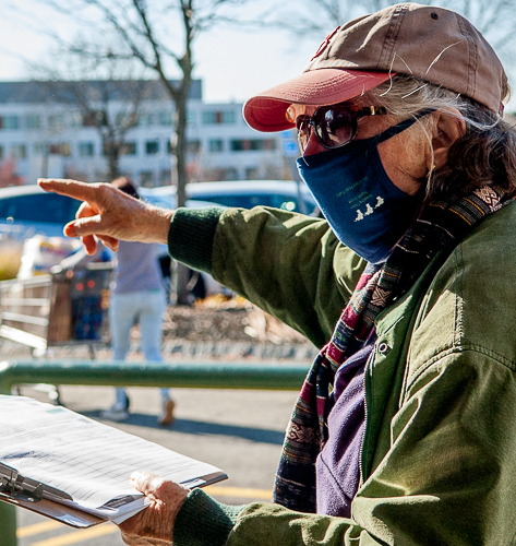 Woman gathering petitions at Market Basket points to proposed peaker location