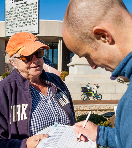 Patricia Sullivan collects signature on petition from shopper at Market Basket