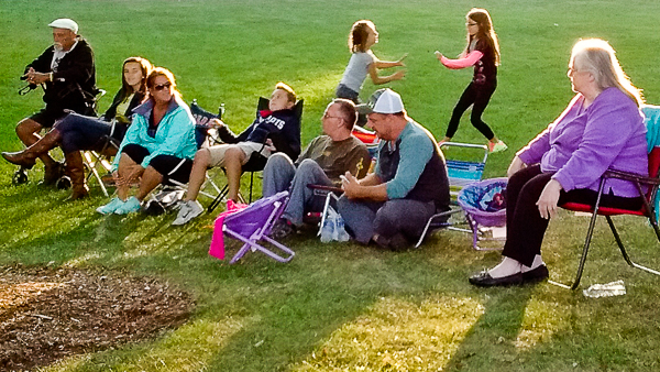 People relax on lawn while listening to concert
