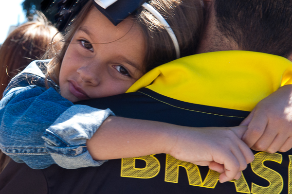 Father carries daughter while watching performance