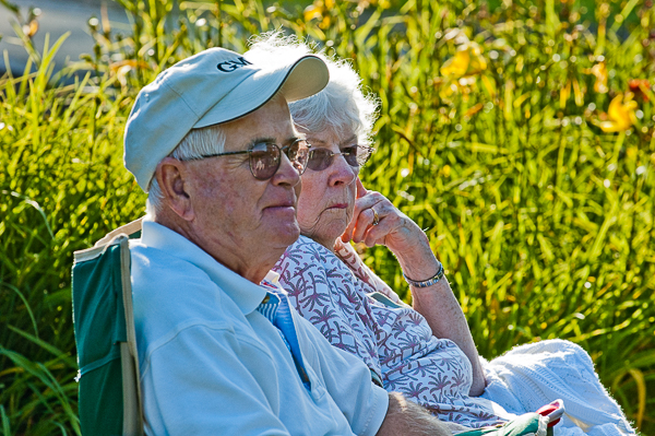 A couple sit in chairs while listening to concert