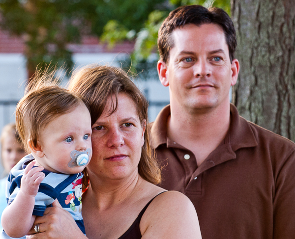 Father and mother holding child listen to concert