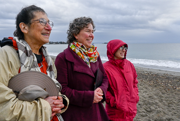 Judith Black, Reverend Kendra Ford, and Reverend Jenna Crawford looking at sun streaming through a break in the clouds