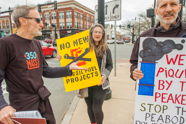 Jim Mulloy, Amanda Nash, and Rob Bonney display signs at standout