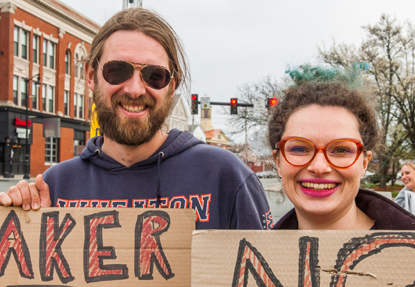 Demonstrators holding signs at standout in Peabody Square