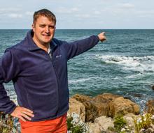 Jake Vaillancourt, pointing to sea and horizon