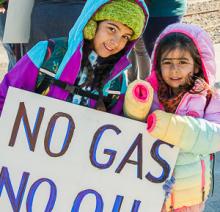 LLuveia and Amaya Luz Segura-Leigh holding sign "No gas No oil"